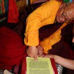 H.E. Dorje Rinzin Rinpoche, master of the seventh Dzogchen Dharma King in China, stamps his fingerprint onto the congratulatory letter he wrote to H.H. Dorje Chang Buddha III.