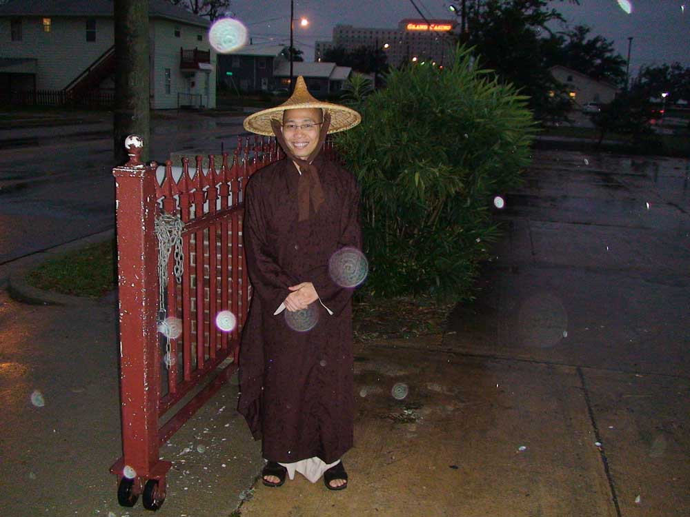 Ven. Thich Thien Tri at the gate to the Chau Van Duc Vietnamese Temple. Many Dharma Wheel Mandalas can be seen with this smiling monk.