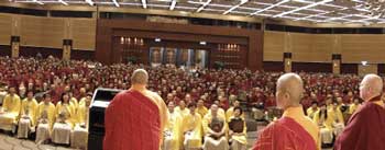 he chairperson of the International Buddhism Sangha Association, Dharma Master Long Hui Lajian Rinpoche, gives a speech in Hongkong directed at the fifty newly qualified Acaryas (yellow robes) and one thousand Masters of Dharma-Listening Sessions (maroon robes) while members of the Examination Committee, Ruo Hui Fa Shi and Ven. Zhaxi Zhuoma Rinpoche look on.